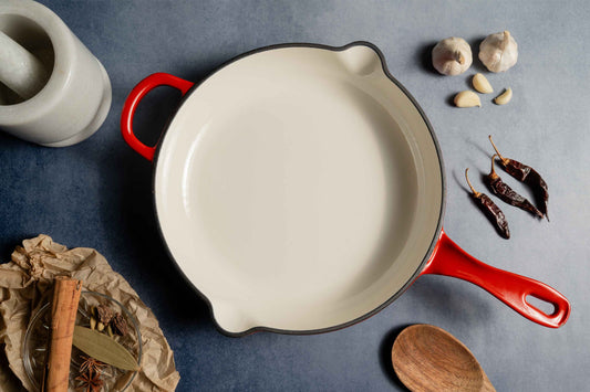 Elvira 25cm Enamel Coated Cast Iron Pan on Table with Red Handle
